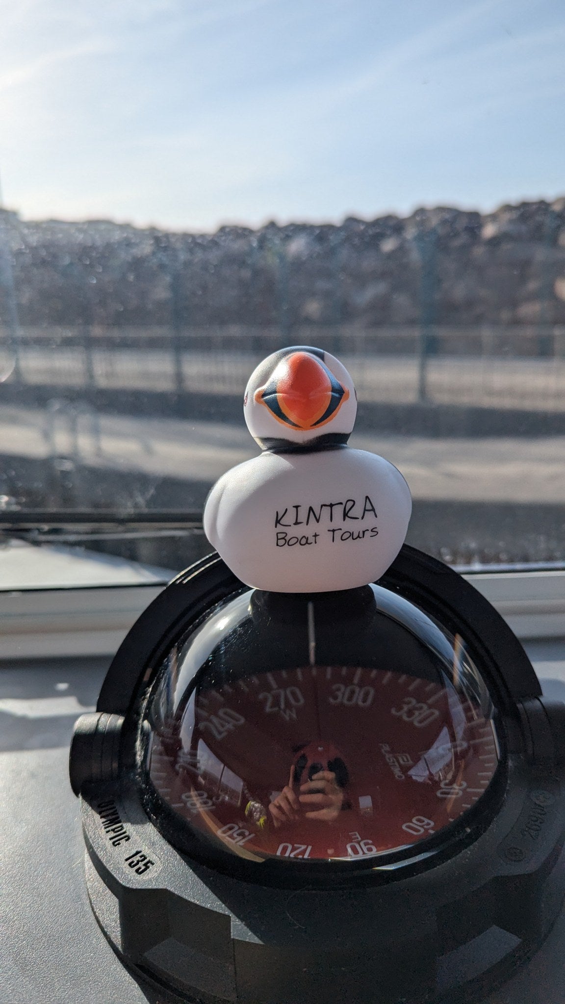 Penny, the Kintra rubber puffin, perched on the compass in the wheelhouse.